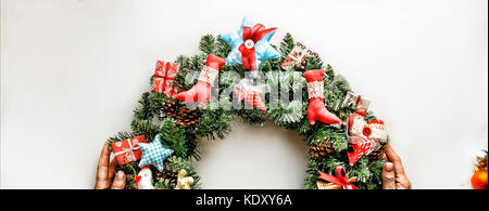 2018 anno nuovo. Ghirlanda di Natale. tonica immagine. vacanze di Natale. Ghirlanda di Natale nelle mani di donne isolate su bianco. giocattoli di Natale su una bianca Foto Stock