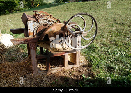 Vecchio canto-driven macchina di trebbiatura Foto Stock