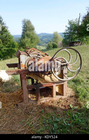 Vecchio canto-driven macchina di trebbiatura Foto Stock