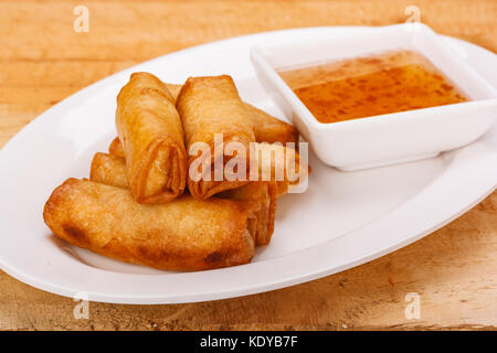 Croccanti involtini primavera sul piatto con salsa di prugne Foto Stock