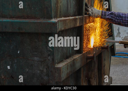 Saldatore lavoratore con cannello da taglio il taglio di un acciaio ossigeno propano cannello da taglio utilizzato Foto Stock