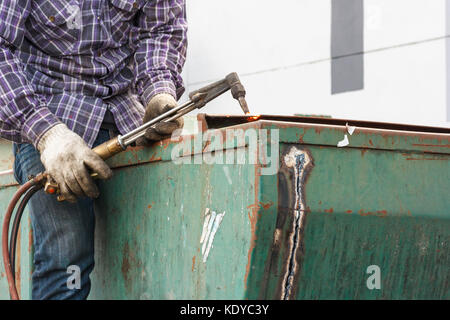 Saldatore lavoratore con cannello da taglio il taglio di un acciaio ossigeno propano cannello da taglio utilizzato Foto Stock