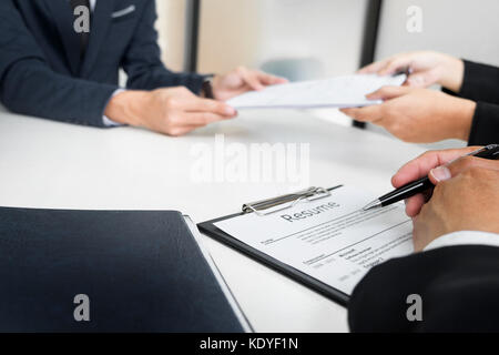 Le mani di uomo di dare applicazione al portafoglio uomo HR in ufficio per intervista Foto Stock