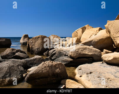 Caduta massi di pietra calcarea e le rocce vicino alla costa di Gozo a Malta Foto Stock