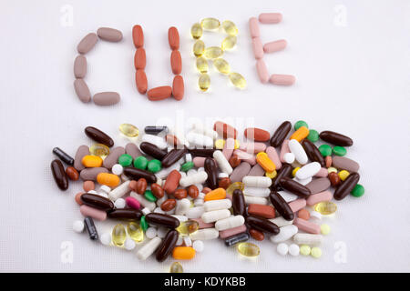 Mano concettuale di scrittura di testo Didascalia ispirazione cure mediche concetto di salute scritto con le pillole farmaci capsula Cura di parola su bianco sfondo isolata w Foto Stock