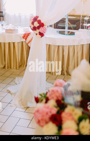 La parte delle nozze arch decorate con il rosso e bianco di rose. Foto Stock