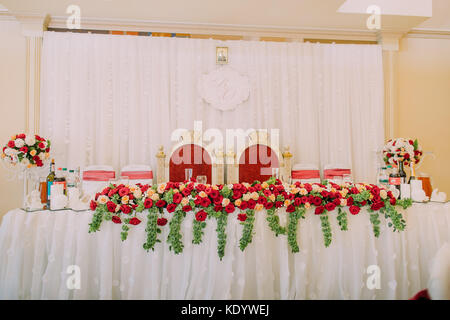 Close-up foto del matrimonio set tavola decorata con rose rosse. di stile antico. Foto Stock