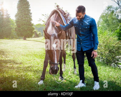 Uomo con cavallo sulla natura Foto Stock