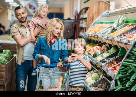 Famiglia con carrello nel supermercato Foto Stock