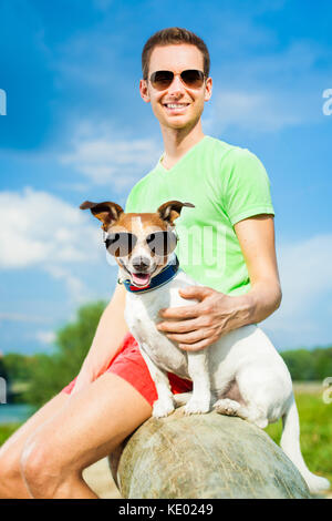 Cane e proprietario osservando insieme , seduta molto vicino insieme avente un buon tempo all'aperto nel parco Foto Stock