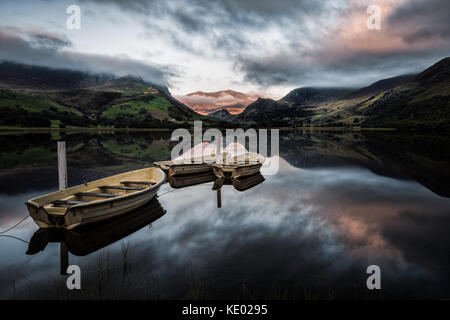 Barche riflessa ormeggiata su calma Llyn Nantlle con Snowdon in distanza, Gwynedd, Wales, Regno Unito Foto Stock