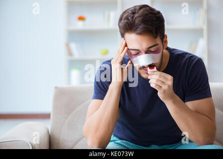 Giovane uomo recuperando la guarigione a casa dopo un intervento di chirurgia plastica naso job Foto Stock