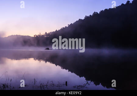 Ambiente attività outdoor, flottante bamboo rafting al mattino nel lago tranquillo con la luce del sole e la nebbia acqua circondati dalla valle e Foto Stock