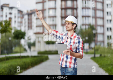 Giovane architetto di fronte all edificio di appartamenti Foto Stock