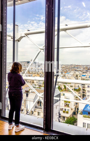 Donna si affaccia sui tetti di Parigi dal Centro Pompidou di Parigi Foto Stock