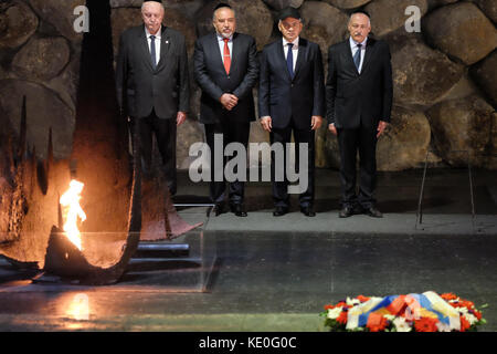 Gerusalemme, Israele. Xvii oct, 2017. Il ministro della difesa della Federazione russa, il generale dell esercito, Sergei shoigu (seconda a destra), riaccende la fiamma eterna e depone una corona di fiori come egli partecipa in una cerimonia commemorativa nella sala della rimembranza. scortato da Israele il ministro della difesa, Avigdor Lieberman (seconda a sinistra), shoigu ha visitato lo Yad Vashem Holocaust Museum, ha partecipato ad una cerimonia commemorativa, ha visitato i bambini memorial e firmato il museo guest book. Credito: nir alon/alamy live news Foto Stock