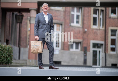 Wolfgang Krogmann, il capo del braccio tedesco della Primark, tiene una borsa Primark a Münster, in Germania, il 17 ottobre 2017. La catena sta aprendo un nuovo outlet in città. Foto: Guido Kirchner/dpa Foto Stock