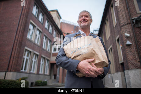 Wolfgang Krogmann, il capo del braccio tedesco della Primark, tiene una borsa Primark a Münster, in Germania, il 17 ottobre 2017. La catena sta aprendo un nuovo outlet in città. Foto: Guido Kirchner/dpa Foto Stock