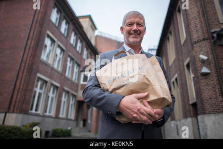 Wolfgang Krogmann, il capo del braccio tedesco della Primark, tiene una borsa Primark a Münster, in Germania, il 17 ottobre 2017. La catena sta aprendo un nuovo outlet in città. Foto: Guido Kirchner/dpa Foto Stock