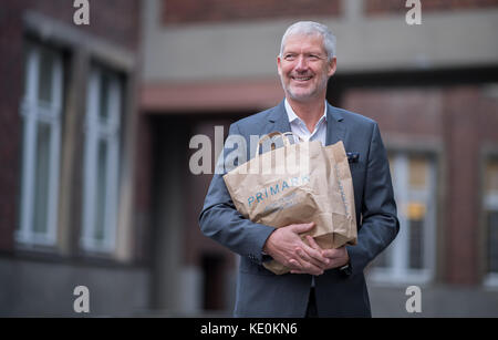 Wolfgang Krogmann, il capo del braccio tedesco della Primark, tiene una borsa Primark a Münster, in Germania, il 17 ottobre 2017. La catena sta aprendo un nuovo outlet in città. Foto: Guido Kirchner/dpa Foto Stock