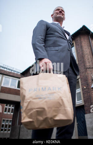 Wolfgang Krogmann, il capo del braccio tedesco della Primark, tiene una borsa Primark a Münster, in Germania, il 17 ottobre 2017. La catena sta aprendo un nuovo outlet in città. Foto: Guido Kirchner/dpa Foto Stock