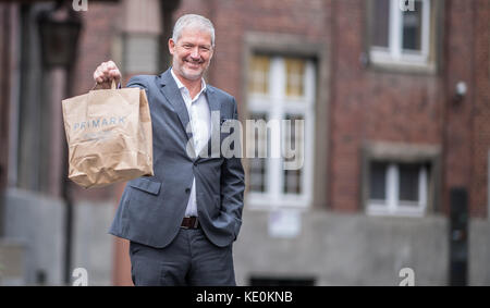 Wolfgang Krogmann, il capo del braccio tedesco della Primark, tiene una borsa Primark a Münster, in Germania, il 17 ottobre 2017. La catena sta aprendo un nuovo outlet in città. Foto: Guido Kirchner/dpa Foto Stock