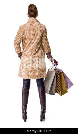 In inverno le cose. visto da dietro la giovane donna in cappotto invernale isolato su bianco con borse per lo shopping Foto Stock