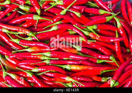 Sottile di peperoni rossi su una pila texture di sfondo Foto Stock