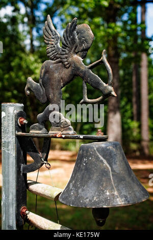 Conroe, Texas, USA - 17 agosto 2017 - Cupido e una campana in un vecchio cimitero Foto Stock