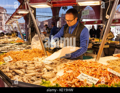 Venezia Italia Venezia pescivendolo la vendita di pesce e frutti di mare freschi dal mercato bancarelle che vendono pesce fresco nel mercato di Rialto Venezia Italia EU Europe Foto Stock