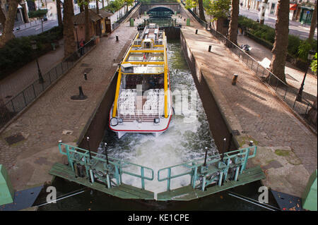 Imbarcazione turistica in una saracinesca, Canal Saint Martin, Paris, Francia Touristenboot in einer Schleuse, Kanal Saint Martin, Paris, Frankreich Foto Stock