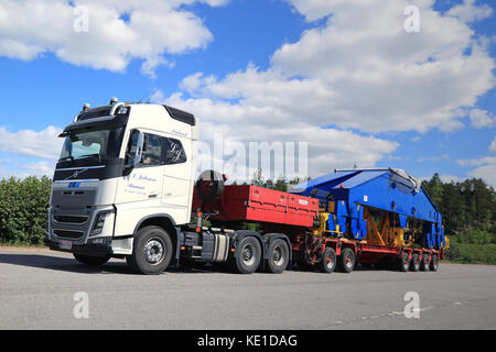 Paimio, Finlandia - 4 giugno 2016: bianco volvo fh16 750 semi trasporti gru di cantiere componente sul rimorchio. La 48-tonnellata di carico è supportato da ruote 24. Foto Stock