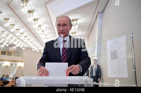 Il presidente russo Vladimir Putin lascia cadere il suo voto in un seggio elettorale nel distretto di Gagarinsky durante le elezioni comunali del 10 settembre 2017 a Mosca, in Russia. Foto Stock