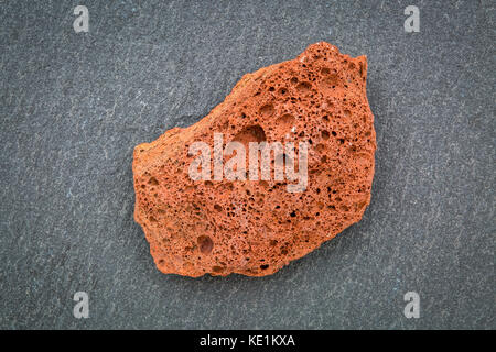 Le scorie di roccia ignea campione nei confronti di ardesia grigia pietra, roccia estrusivo formata dal fast-lava raffreddamento eiettato fuori del vulcano Foto Stock