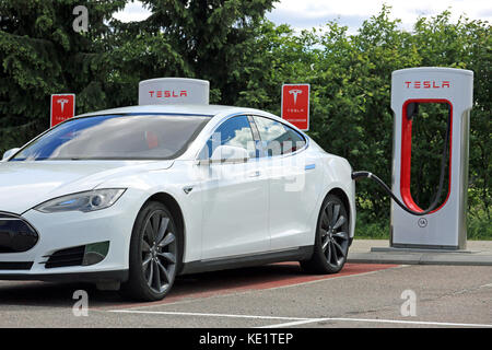 PAIMIO, Finlandia - 4 giugno 2016: Bianco Tesla Model S auto elettrica è in carica di Tesla Supercharger stazione. La carica della batteria da 10 a 80 pe Foto Stock