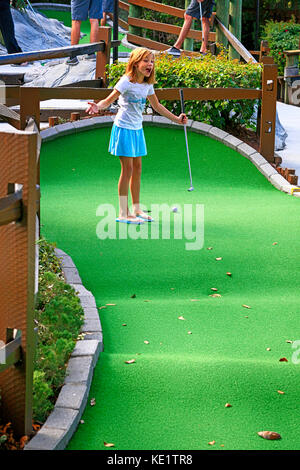 Ragazza di dieci anni che gioca a minigolf a Sarasota, Florida Foto Stock