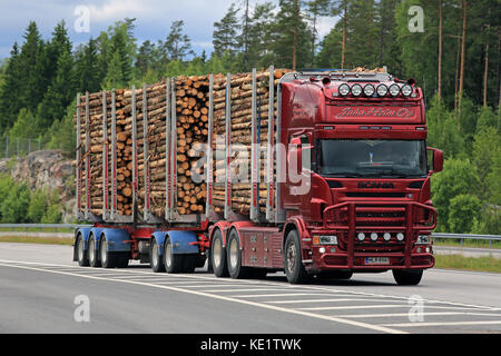 PAIMIO, FINLANDIA – 10 GIUGNO 2016: Il camion rosso Scania trasporta legno di polpa lungo la superstrada. Il mulino per bioprodotti del Gruppo Metsa, attualmente in costruzione Foto Stock