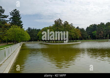 Popolare il parco nord per il resto con autunnale di vecchia foresta panca in legno e il lago nel quartiere vrabnitsa, sofia, Bulgaria Foto Stock