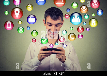 La tecnologia di comunicazione mobile phone high tech concetto. uomo felice utilizzando messaggi di testo sullo smartphone social media le icone delle applicazioni di volare in alto di cellpho Foto Stock