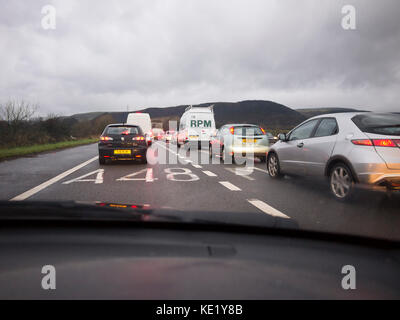 Il maltempo traffico su una strada48 Foto Stock