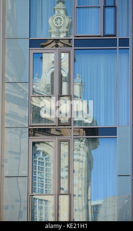 Vecchia chiesa Frauenkirche riflette in vetro specchiato facciata di edificio moderno a Dresda in Sassonia, Germania. Foto Stock