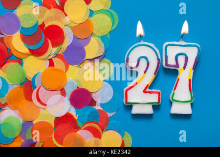 Numero 27 celebrazione candela con party coriandoli Foto Stock