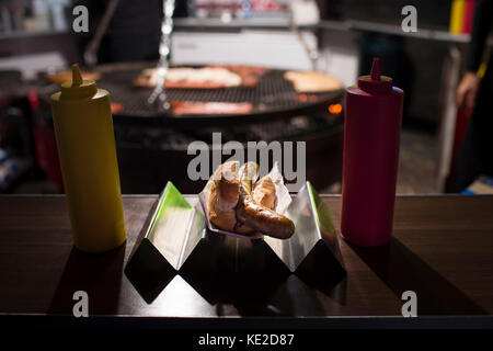 La salsiccia nel pane di sera nello stand di salsiccia Foto Stock