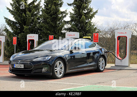 PAIMIO, Finlandia - 29 Aprile 2016: Nero Tesla Model S auto elettrica che opera come un taxi è in carica di Tesla Supercharger stazione di Paimio Foto Stock