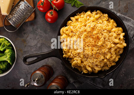 Mac e formaggio in una ghisa padella cotti con pangrattato overhead shot, stile rustico Foto Stock