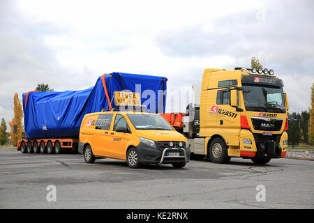 FORSSA, Finlandia - 13 ottobre 2017: Giallo MAN TGX 41.640 semi carrello ampia di carico e di trasporto Mercedes-Benz pilota del veicolo pesante Silvasti parcheggiato su t Foto Stock