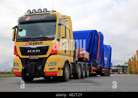 Forssa, Finlandia - 13 ottobre 2017: giallo man tgx 41.640 semi carrello carico di larghezza di trasporto pesante silvasti parcheggiato sul cantiere di asfalto di un arresto carrello Foto Stock