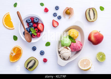 Coloratissimo gelato misto con bacche e frutti vari ,Lampone Mirtillo ,fragola ,fetta di arancia , dimezzare kiwi ,apple,limone e menta piperita o di configurazione Foto Stock