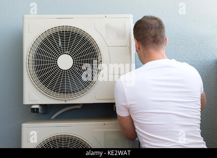 Tecnico maschile che installa l'impianto di climatizzazione. Foto Stock