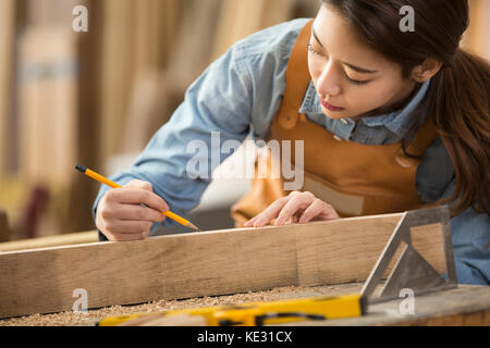 Ritratto di giovane donna falegname concentrare sul suo lavoro Foto Stock